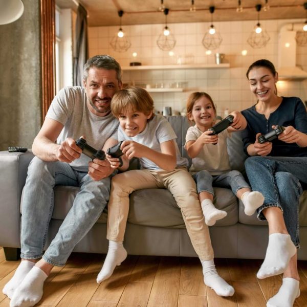 Overjoyed family with kids play video games at home